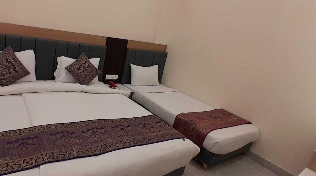 A double bed with a headboard, two pillows, and a decorative throw.