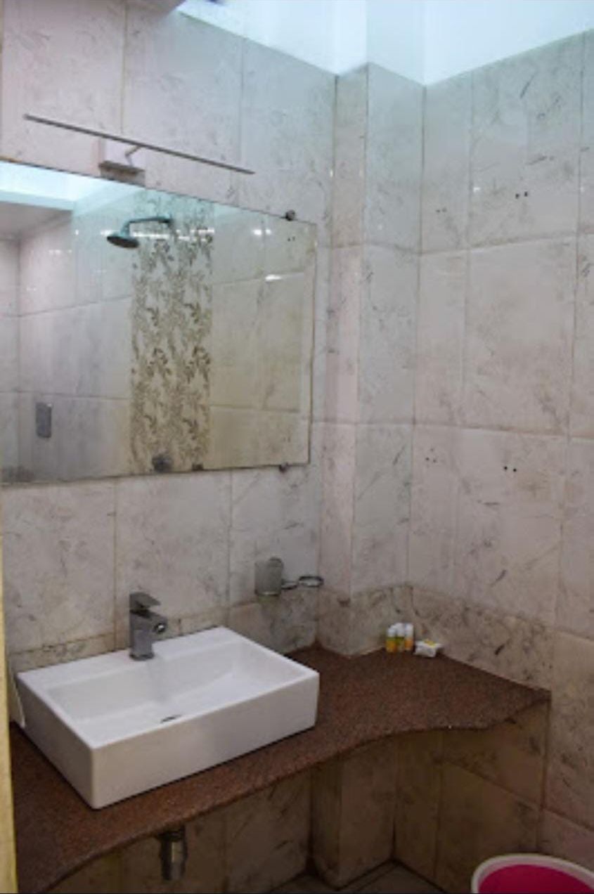 A bathroom with a white sink, a mirror, and a shower.