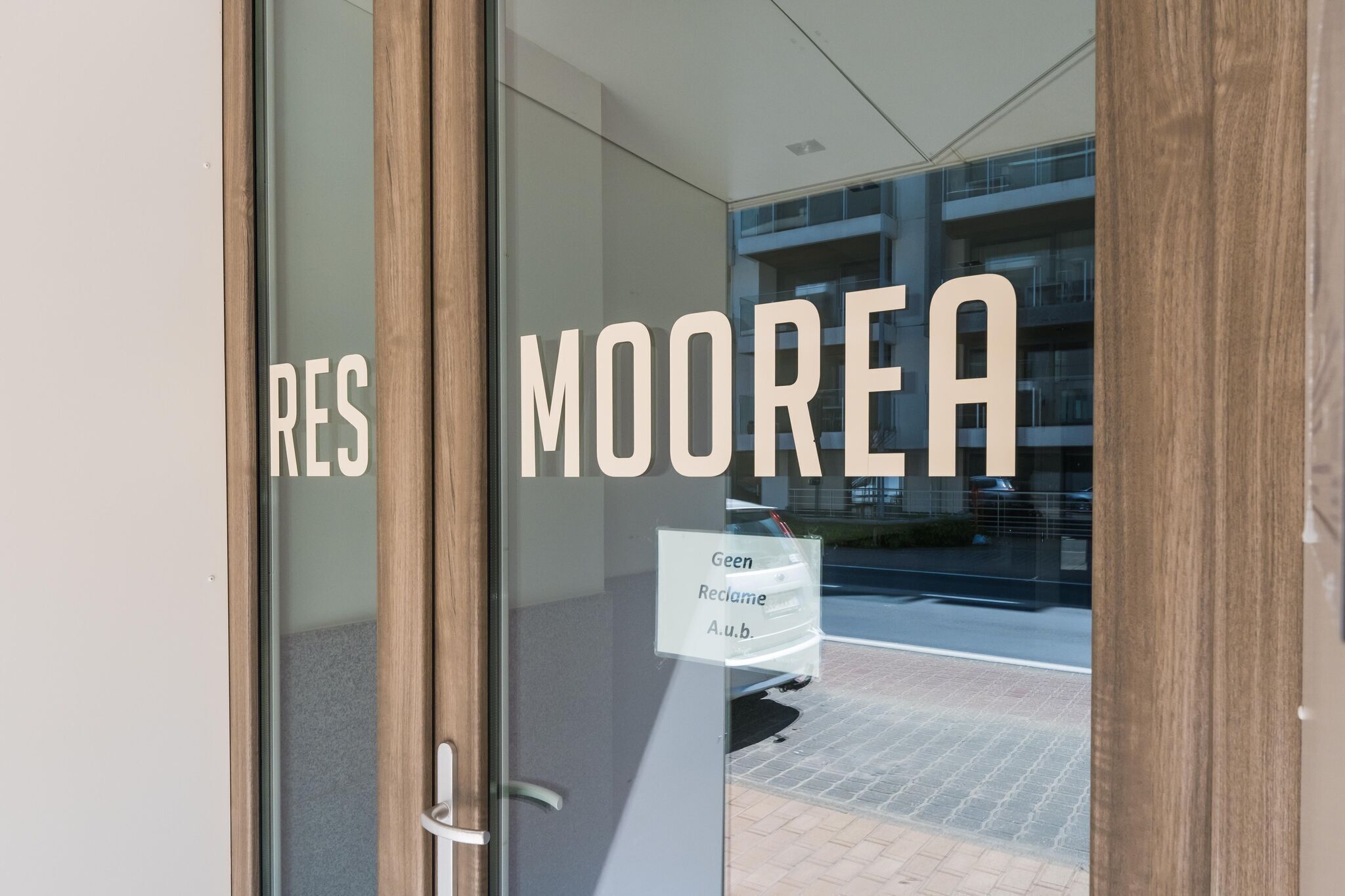 Ein Hotel Eingang mit dem Schriftzug 'RES MOOREA' auf der Glastür.