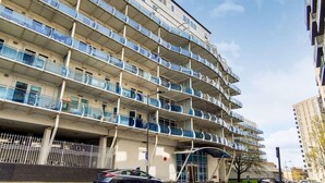A multi-story residential building with balconies, a covered entrance, and a parking area. - Stay by the coastal trails, Middelkerke (Middelkerke)