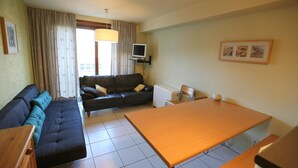 A compact hotel room with a sofa, a dining table, a television, and a small kitchenette. - Stay by the coastal trails, Middelkerke (Middelkerke)
