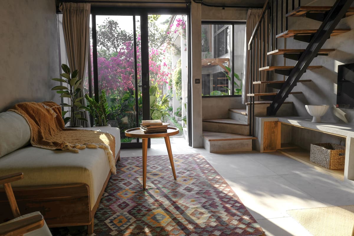 A modern living room with a sofa, a coffee table, and a staircase.