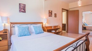 Een hotelkamer met een houten bed, nachtkastjes, een spiegel en wanddecoratie.