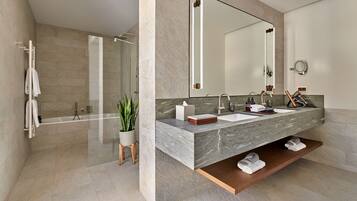 A modern bathroom with a large mirror, dual sinks, and a shower area.