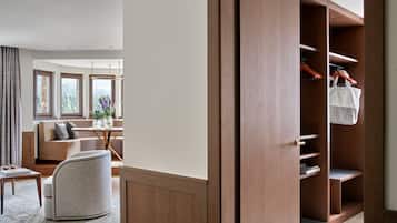 Een moderne woonkamer met een bank, een fauteuil, een tafel en een groot raam.