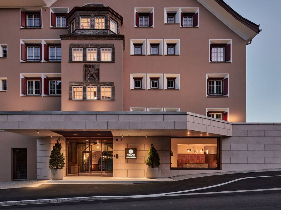 A hotel with a modern facade, multiple windows, and a well-lit entrance.