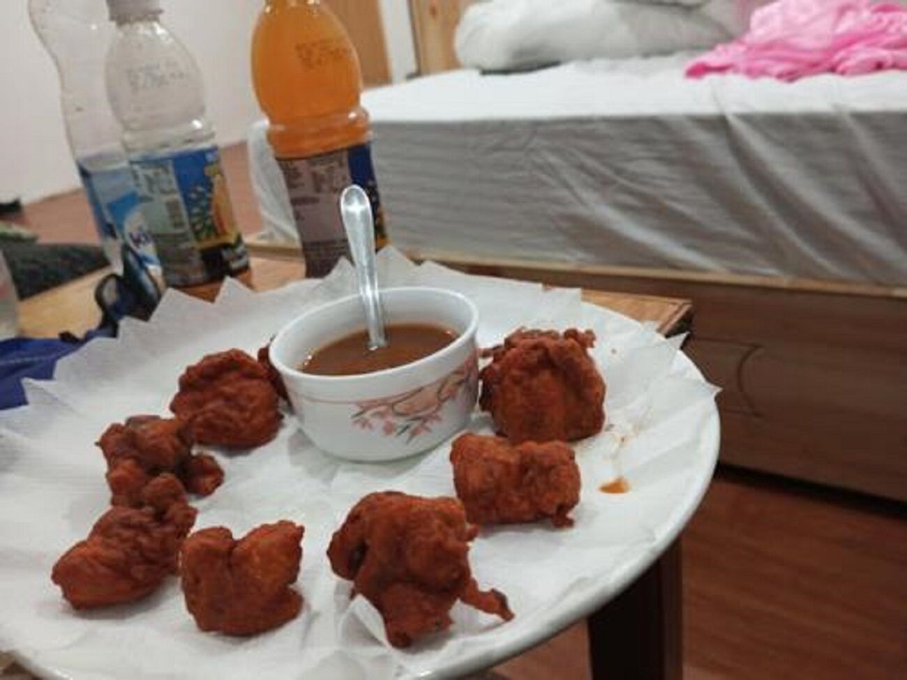Una mesa con un tazón de sopa y varios bocados fritos.