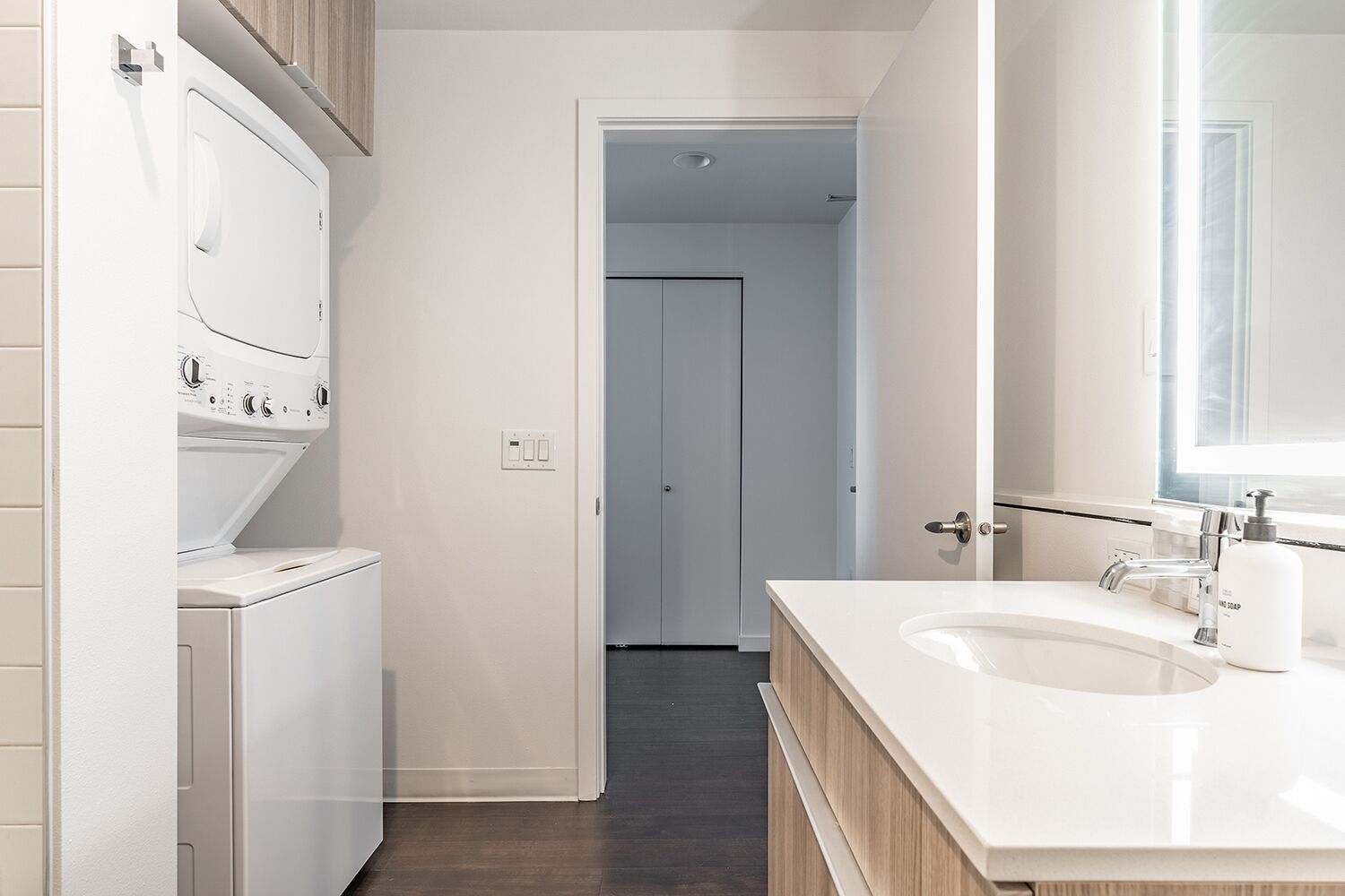 A modern bathroom with a white sink, a mirror, and a shower area.