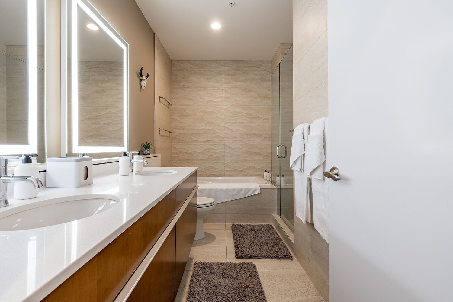 Un baño moderno con dos lavamanos, un inodoro y una ducha.