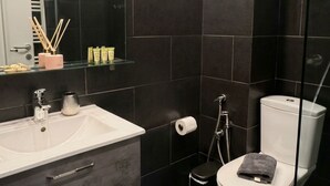 Une salle de bain moderne avec un lavabo blanc, un miroir et des toilettes.