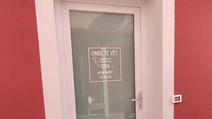 A door with a frosted glass panel and a sign that reads "ONDE TE VÈ?" and "APARTMENT LA SPEZIA".