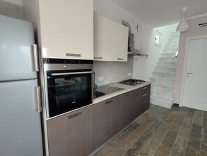Een moderne keuken met roestvrijstalen apparatuur, een gasfornuis en een inbouwoven.
