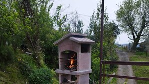 A wooden picnic table with a stone fire pit in the background.