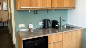A kitchen with wooden cabinets, a dishwasher, a coffee maker, and a sink.