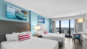 A hotel room with two beds, a desk, and a balcony with a view of the sea. - Coast Comfort Queen Efficiency 4th Floor (Myrtle Beach)
