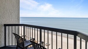 Un balcon avec vue sur la plage et l’océan.