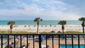 A beach view with a pool area, palm trees, and umbrellas. - Seafaring Adventures Cabana Room 3rd Floor (Myrtle Beach)