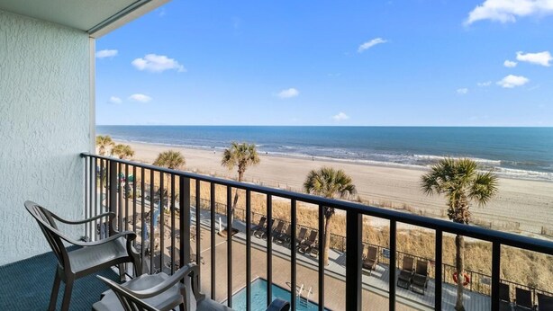 Un balcon avec vue sur la plage et l’océan.