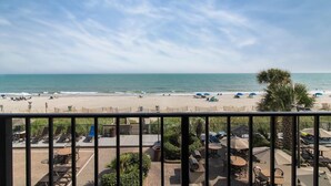 A beach view from a balcony with lounge chairs and umbrellas. - Extravagance Oceanfront Jr Suite 3rd Floor (Myrtle Beach)