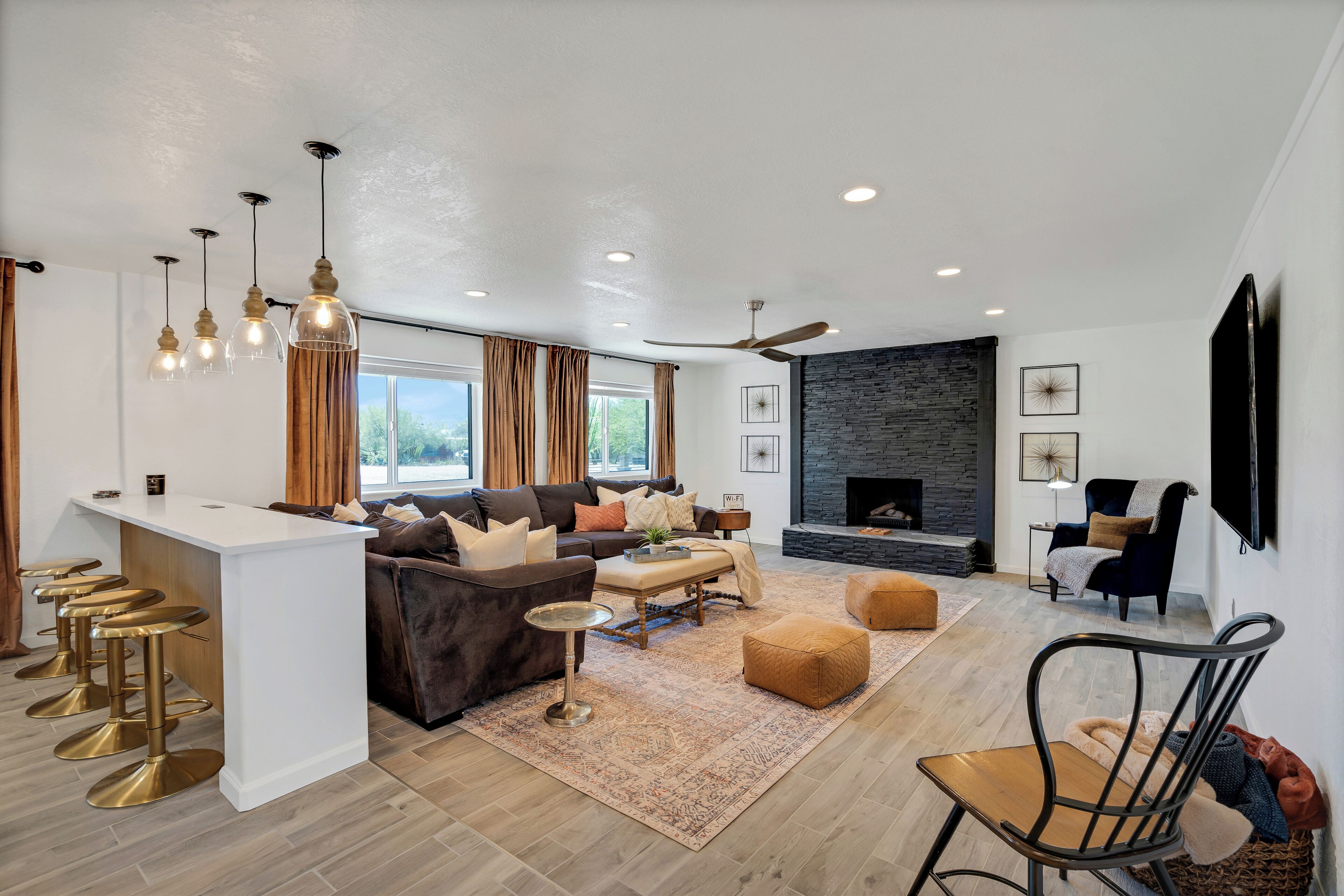 A modern living room with a sofa, ottoman, and a fireplace.