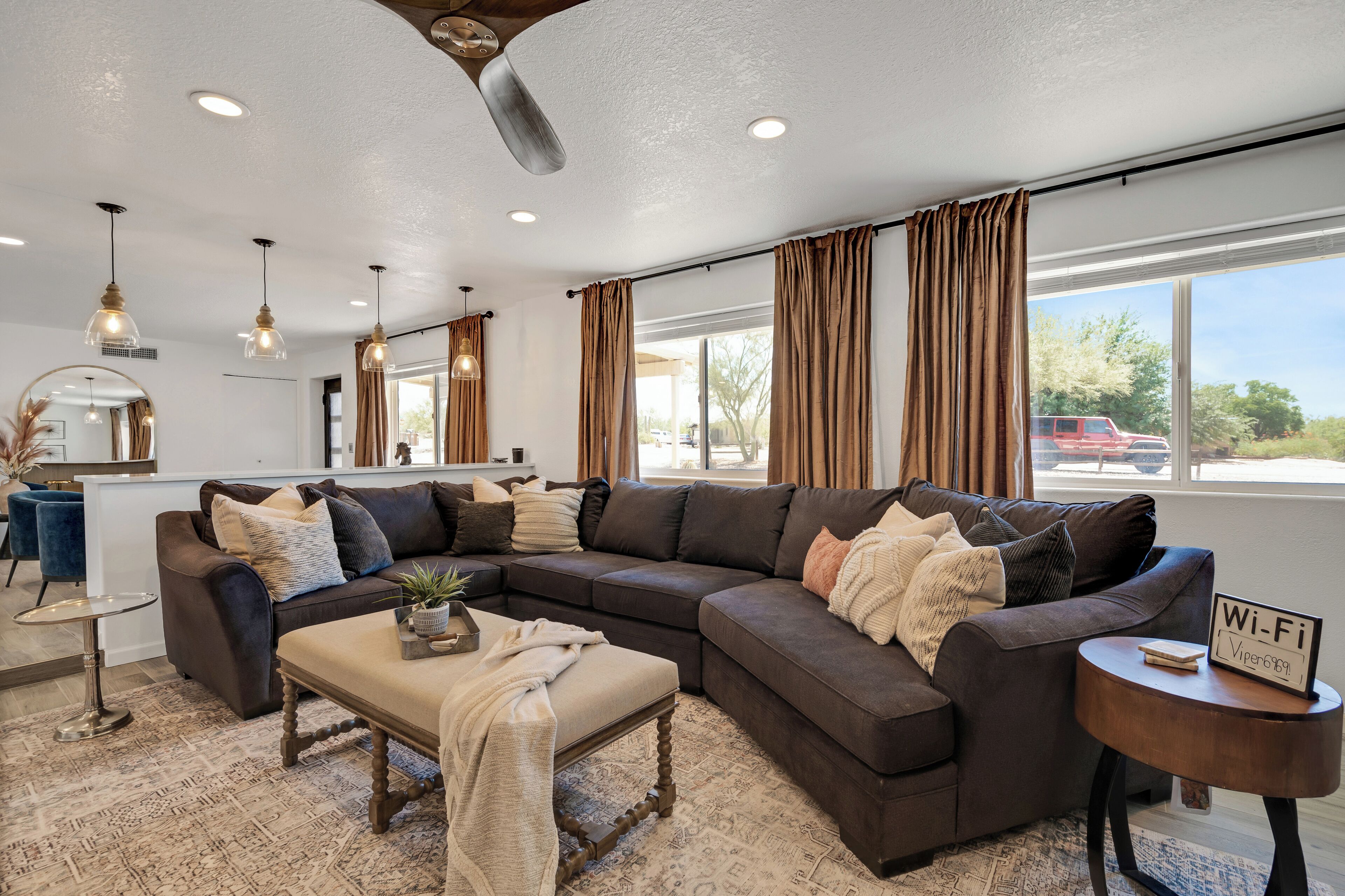 A modern living room with a sectional sofa, a round coffee table, and a small side table with a Wi-Fi sign.