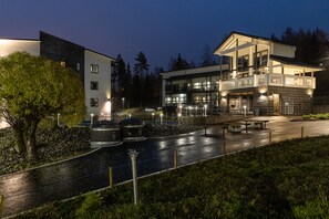 Un hôtel moderne doté d’un vaste espace extérieur, comprenant une piscine et des coins salon.