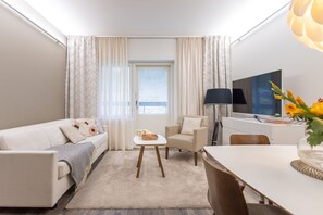 Un salon moderne comprenant un canapé, un fauteuil, une table basse et une table à manger.