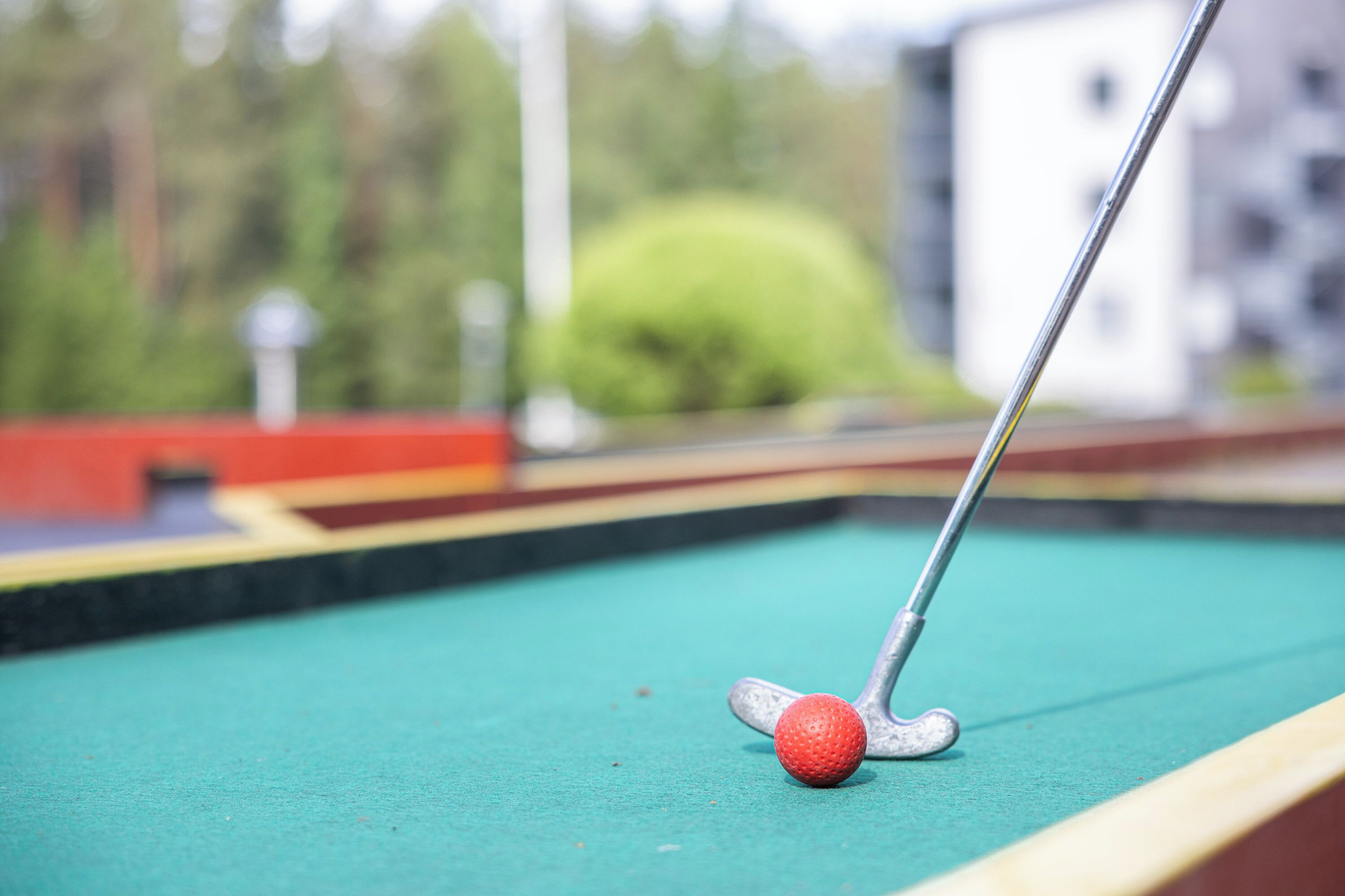 Gros plan d’une queue de billard frappant une boule rouge sur une table de billard verte.
