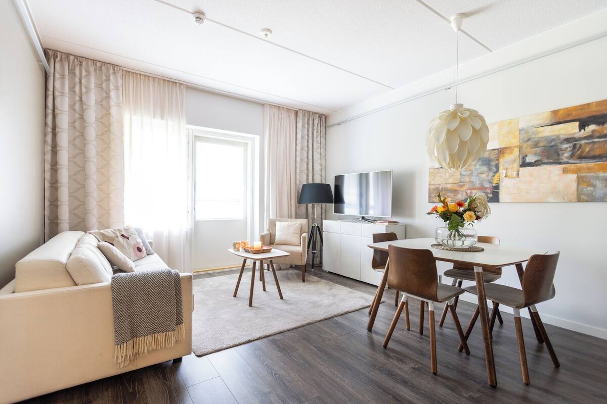Ein modernes Wohnzimmer mit Sofa, Couchtisch und Essbereich.