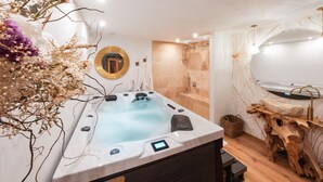 A modern bathroom with a hot tub, a wooden vanity, and a large mirror.