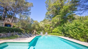 A swimming pool with lounge chairs, surrounded by trees and a building. - Studio Apartment 'Les Cyclamens - Les Oliviers' with Shared Pool, Wi-Fi and Air Conditioning (Saint-Raphaël)