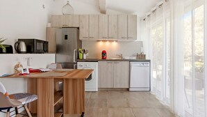 A modern kitchen with wooden cabinets, a stainless steel refrigerator, a microwave, a coffee maker, and a dishwasher. - Studio Apartment 'Les Cyclamens - Les Oliviers' with Shared Pool, Wi-Fi and Air Conditioning (Saint-Raphaël)
