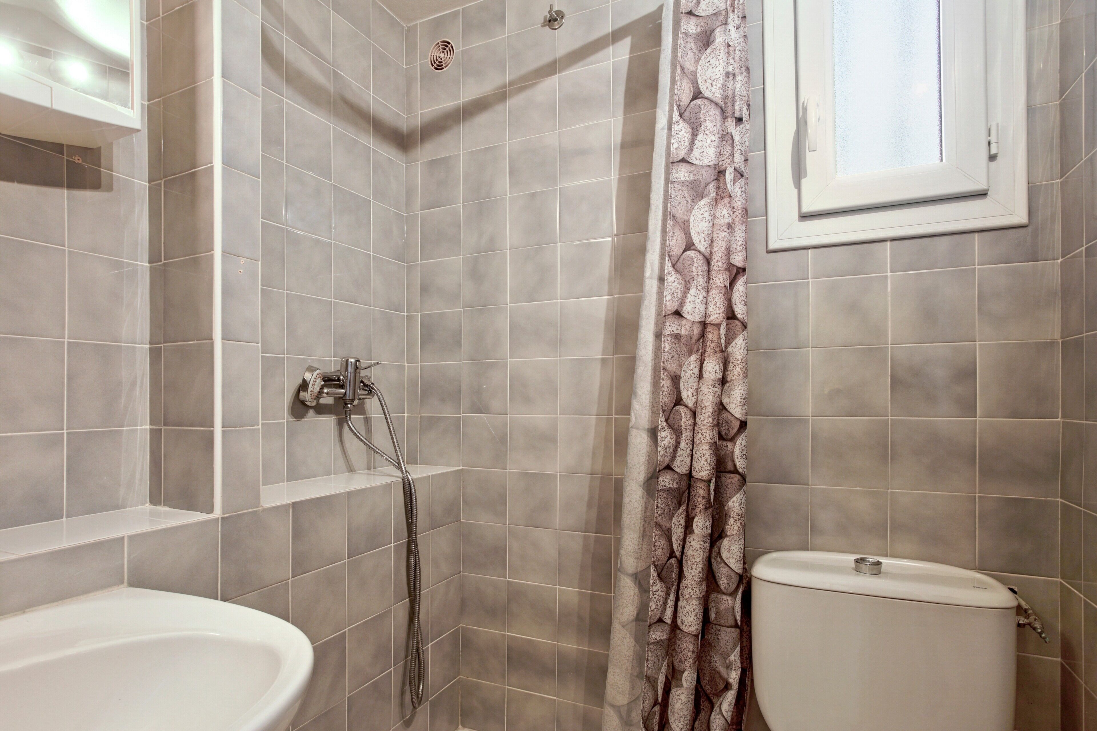 Ein Badezimmer mit Dusche, Toilette und Waschbecken.