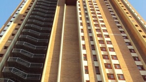 A tall, modern building with multiple floors, featuring a central core and a series of balconies on the left side. - Stunning 1 bedroom apartment with clear views across Benidorm (Benidorm)