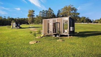 A small, single-story mobile home with a sliding door, a small porch, and a compact kitchen area.