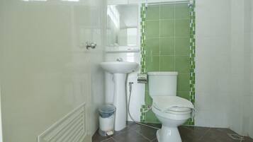 A bathroom with a toilet, sink, and mirror.