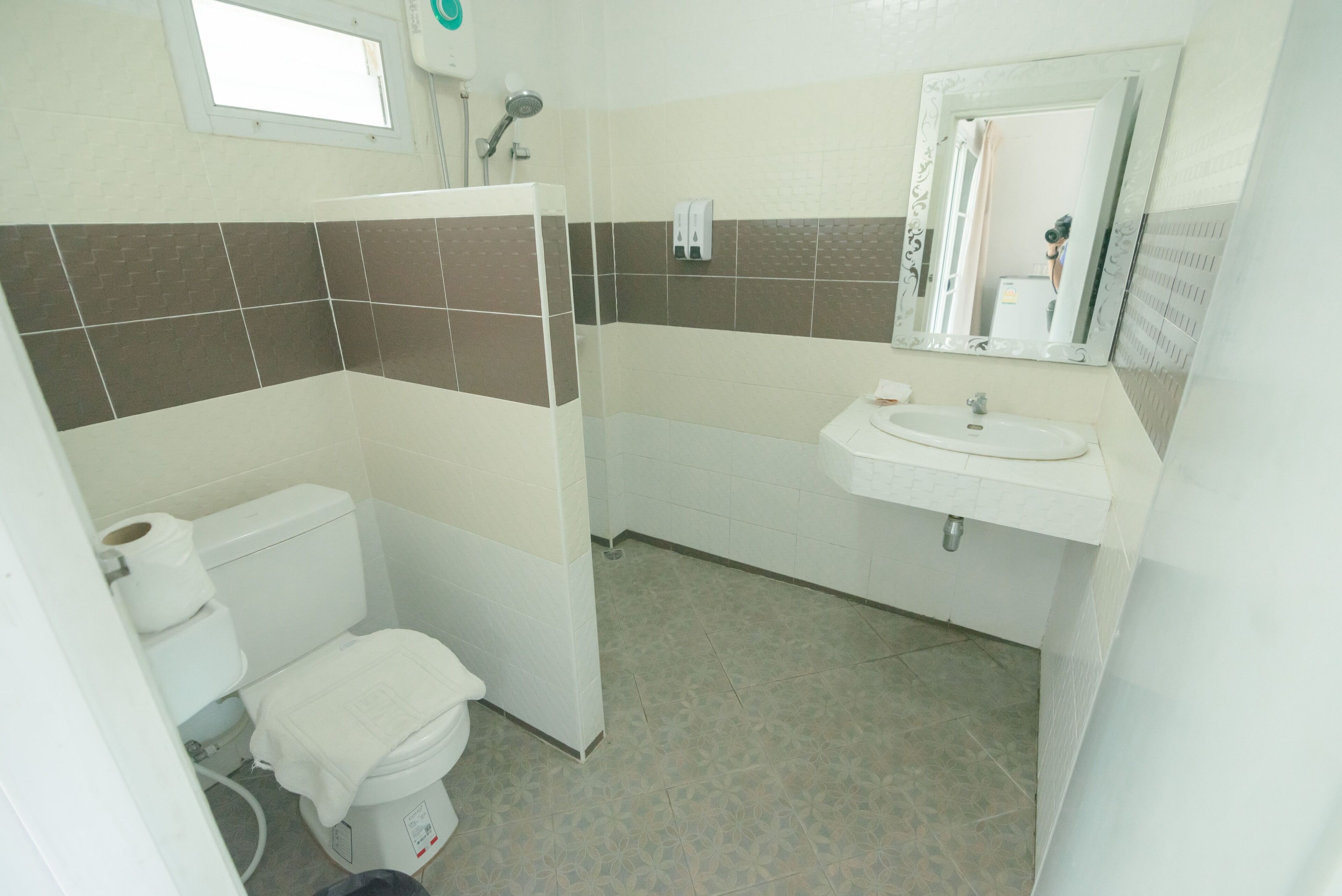 A bathroom with a toilet, sink, and shower.