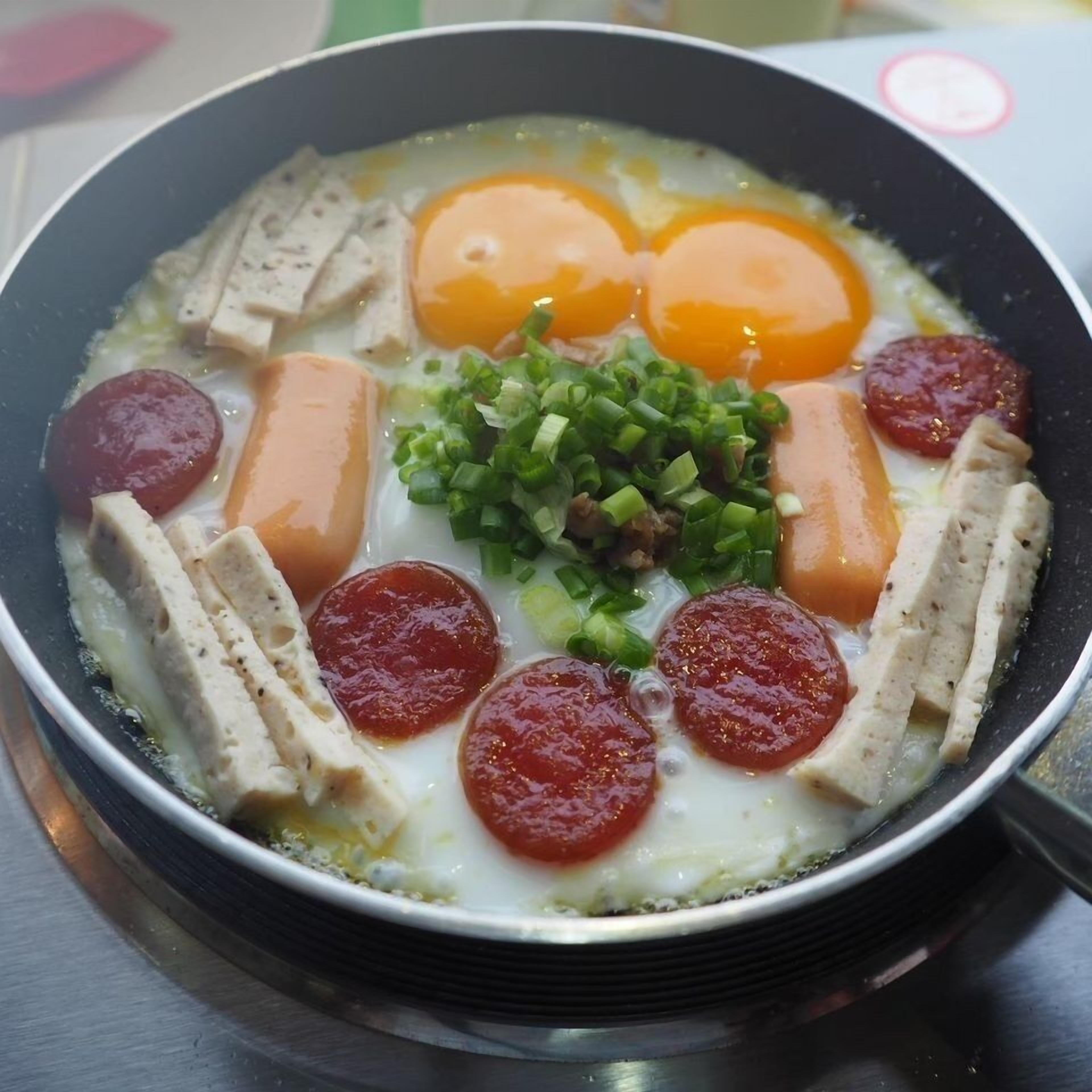 Eine Pfanne mit Essen, darunter Eier, Fleisch und Gemüse.