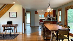 Una cocina amplia con armarios de madera, una mesa de comedor y vistas al exterior.