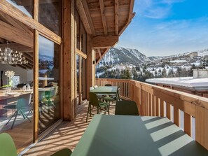 A wooden deck with a table and chairs, overlooking a snowy mountain landscape. - Luxury Chalet 10 pers, SPA, pool, WiFi, Courchevel 1550 (Courchevel 1550)