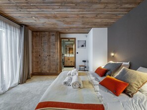Relax in a cozy space with a large bed, seating area, and natural wood accents.