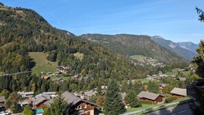 A mountainous village with traditional wooden houses, a clear sky, and a valley view. - Cosy duplex for 6 with 2 balconies & parking in La Clusaz (La Clusaz)
