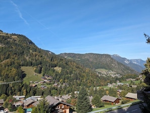 A mountainous village with traditional wooden houses, a clear sky, and a valley view. - Cosy duplex for 6 with 2 balconies & parking in La Clusaz (La Clusaz)