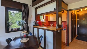 A compact kitchen with a wooden countertop, a dining area with a table and chairs, and a view of the outdoors through a window. - Cosy duplex for 6 with 2 balconies & parking in La Clusaz (La Clusaz)