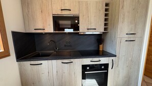 A modern kitchen with a built-in oven, microwave, and sink.