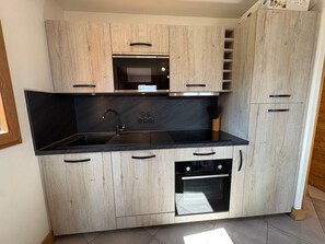 A modern kitchen with a built-in oven, microwave, and sink.