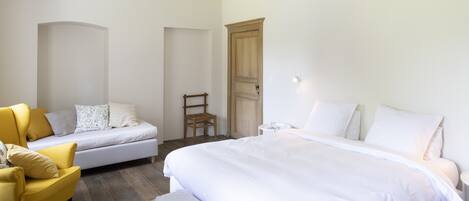 Un dormitorio con cama, sofá, sillón y armario.