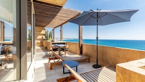 A wooden deck with outdoor furniture, including a table and chairs, and a large umbrella. - Panoramic Ocean View - Hot Tub (San José del Cabo)