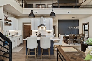 A modern kitchen with a central island, bar stools, and pendant lighting. - Private hot tub, large home, close to downtown (Red Lodge)