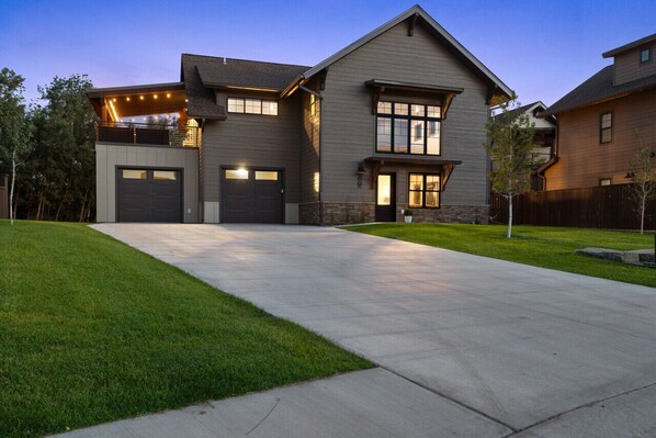 A modern two-story house with a large driveway, a garage, and a well-maintained lawn. - Private hot tub, large home, close to downtown (Red Lodge)